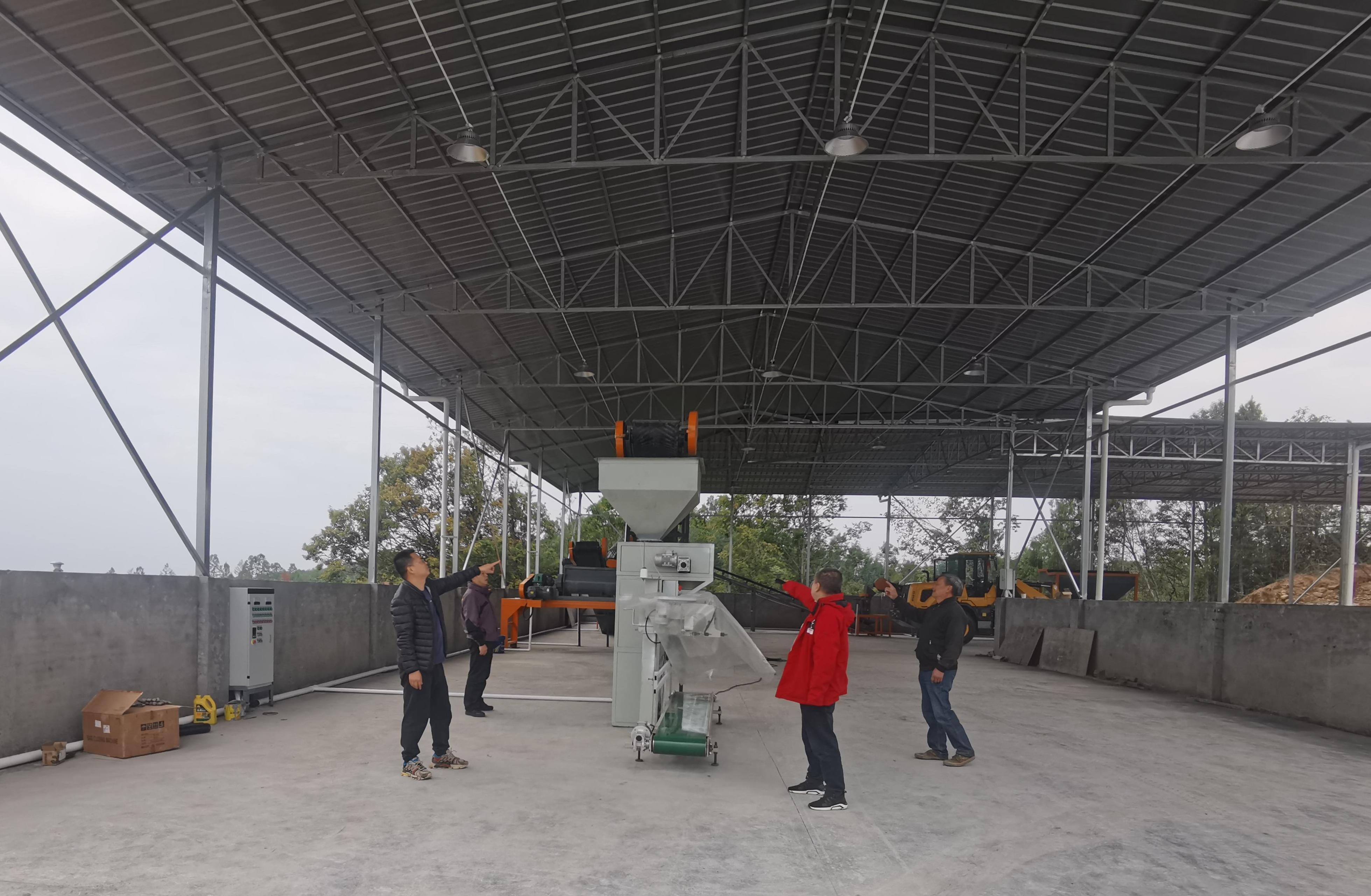 李杰超（左一）與村社干部、駐村隊員查看有機肥廠設(shè)備采購情況